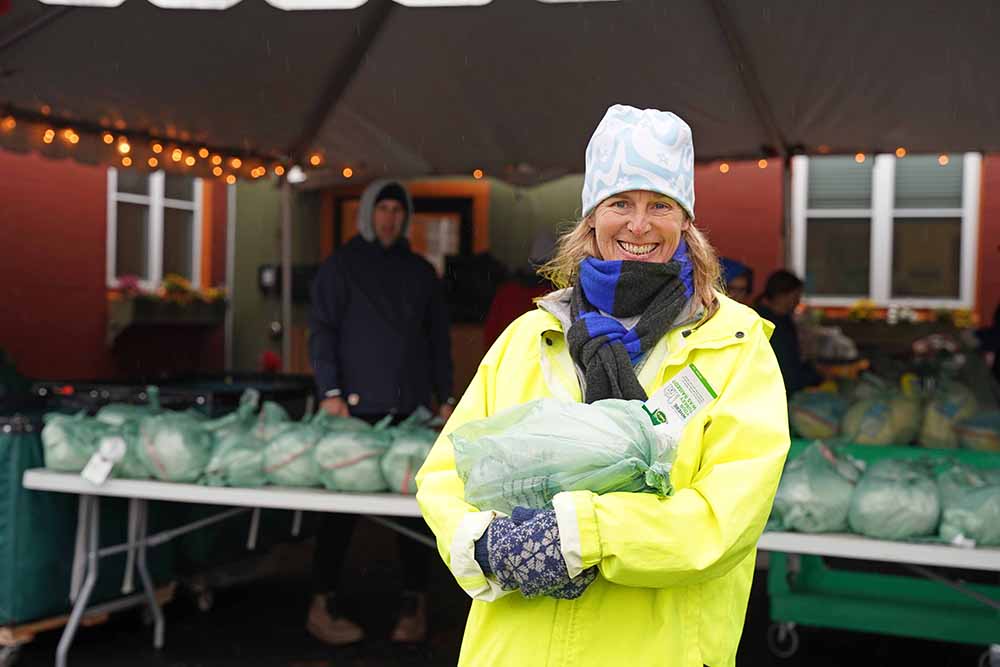 Anika Taylor, of Manchester-by-the-Sea, volunteers to distribute turkeys on Emerson Avenue through The Open Door Holiday Basket program. (Photo Courtesy of The Open Door) 